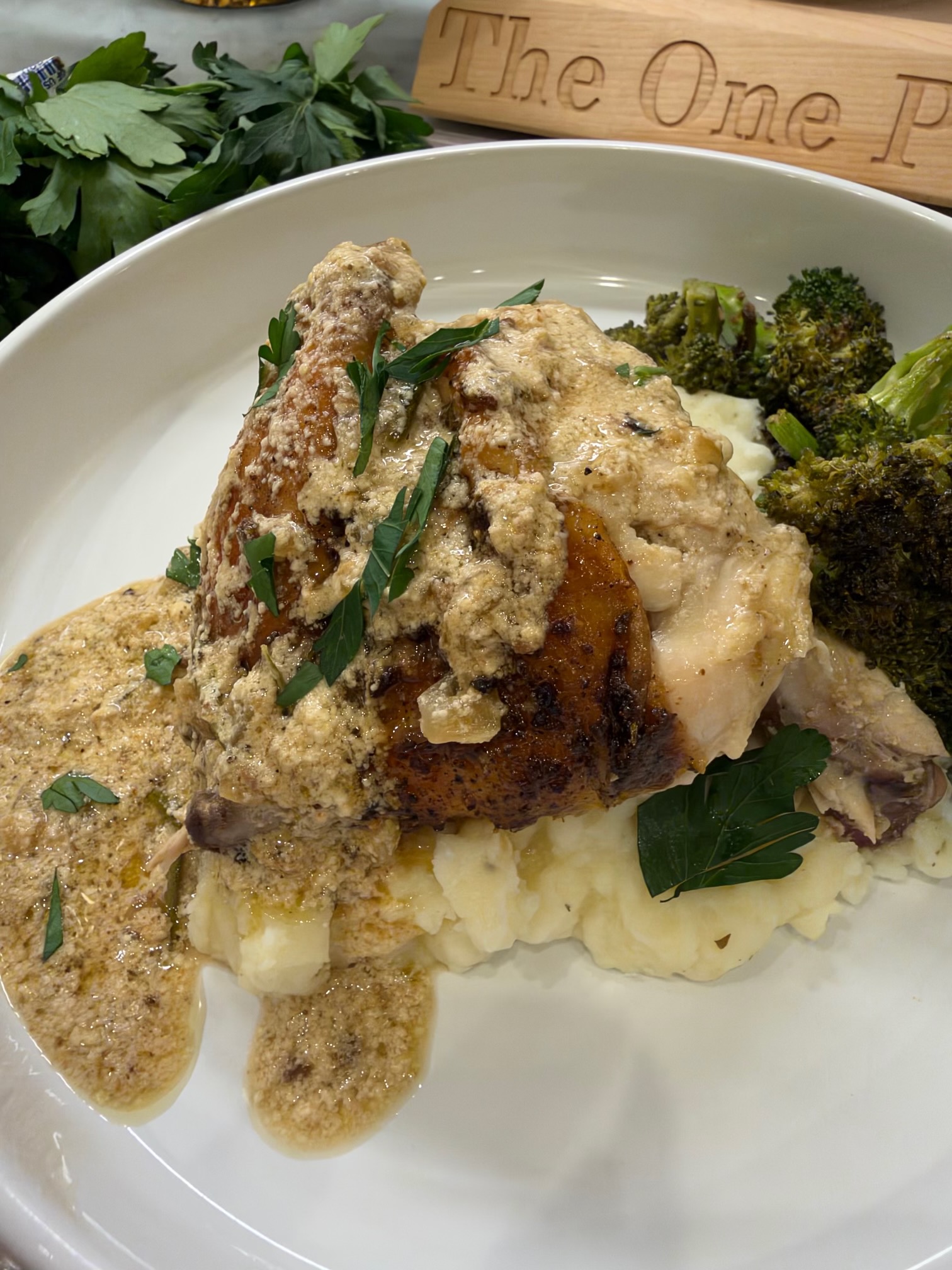 Chicken au poivre with creamy peppercorn sauce and fresh parsley served over mashed potatoes with roasted broccoli.